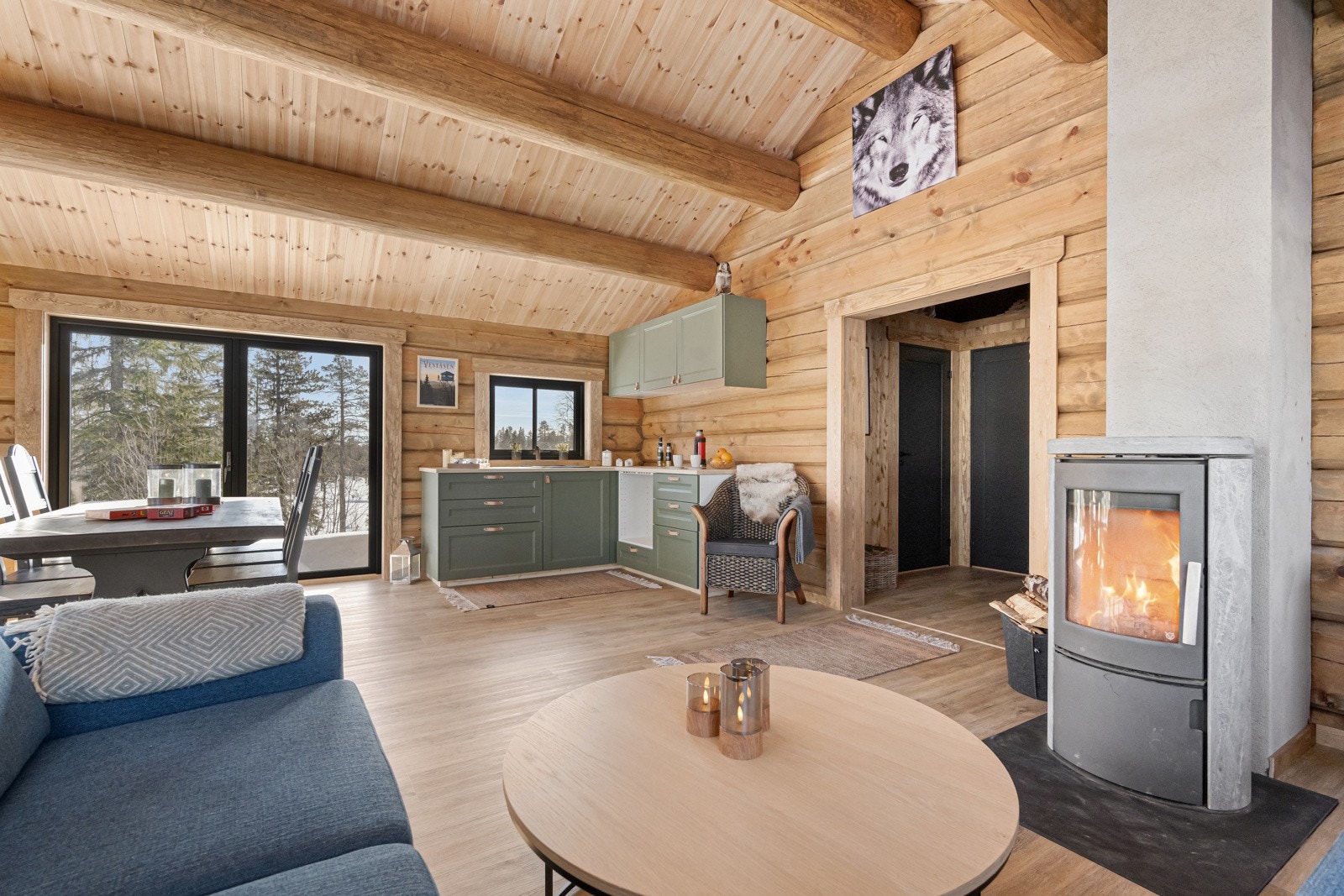 Kjøkken og stue i åpen løsning med synlige åser i himling som gir rommet en ekstra følelse av åpenhet Galleribilde