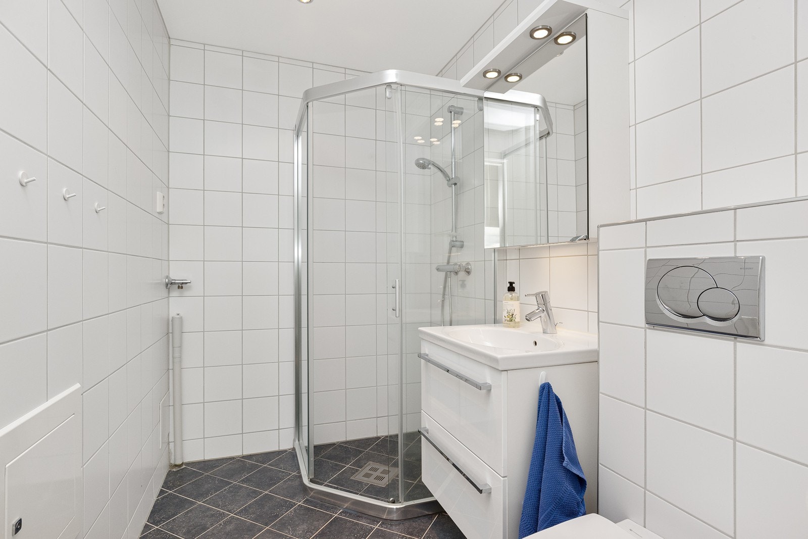 Flislagt og delikat bad i hybel med opplegg for vaskemaskin Galleribilde