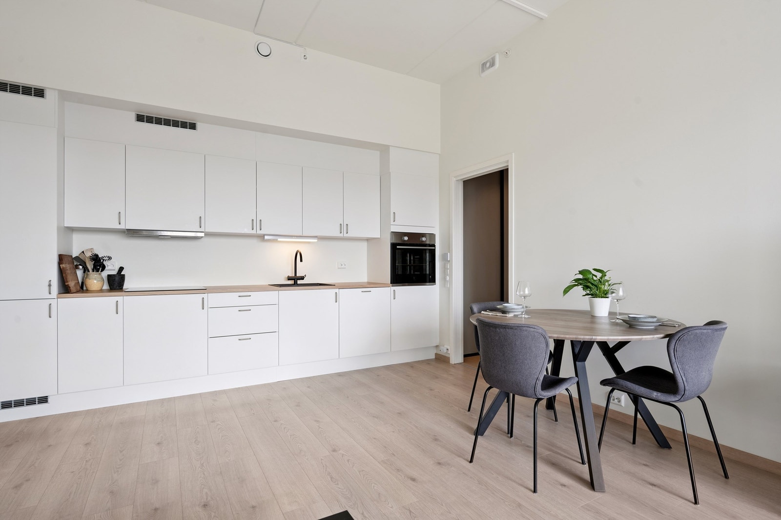 Stilren kjøkkeninnredning med glatte fronter og integrerte hvitevarer Galleribilde