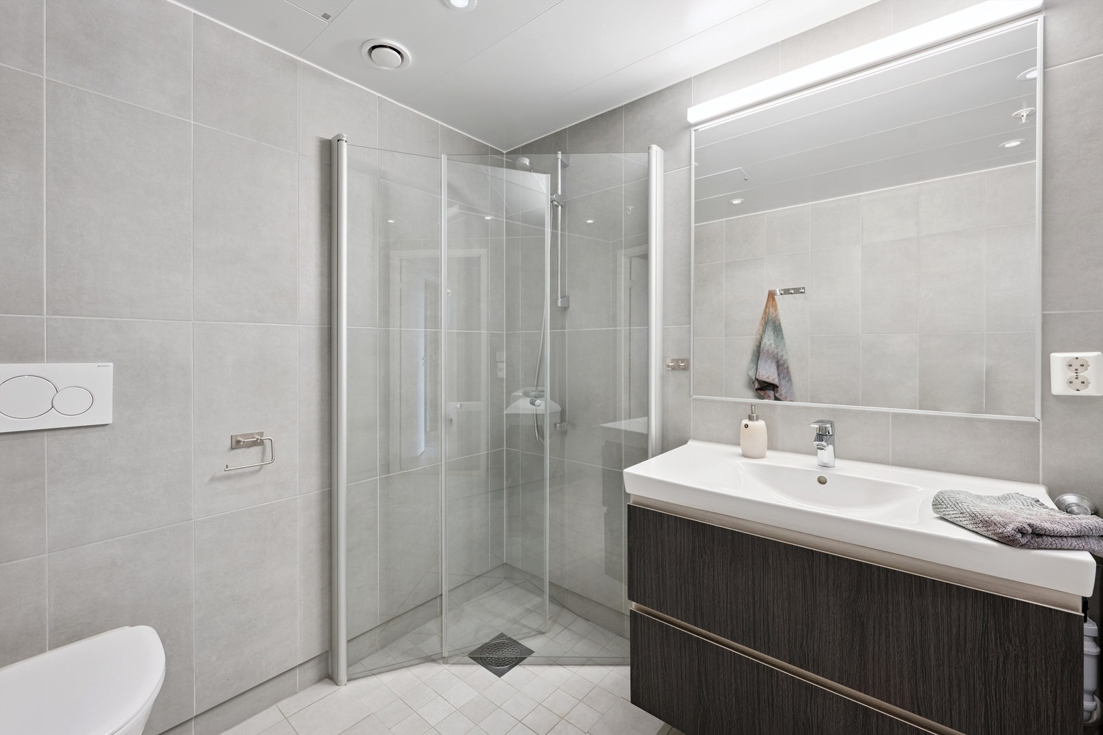 Dusjhjørne med innfellbare glassdører som frigjør gulvplass når det ikke er i bruk. Galleribilde