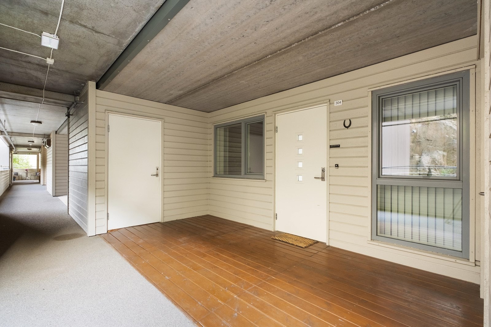 Inngangspartiet har liggende trekledning i lys farge og kan fungere som en ekstra, overbygd veranda. Galleribilde