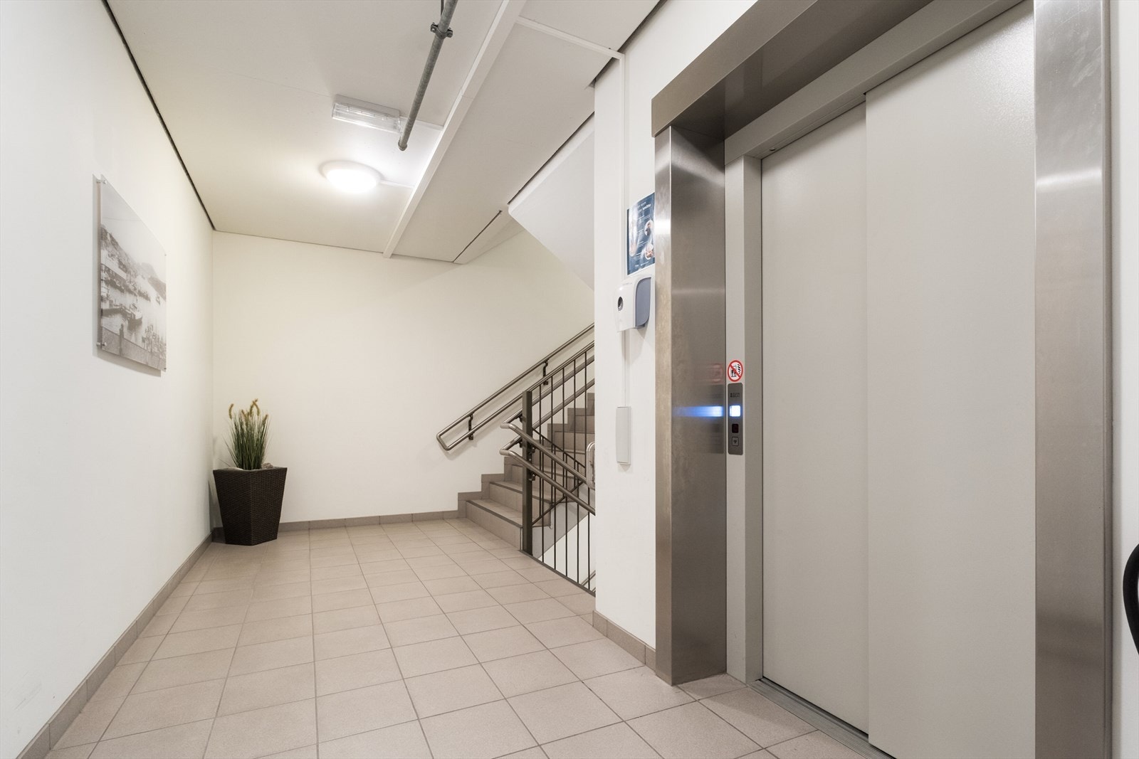 Fellesområdet har enkel adkomst via både trapp og heis, med moderne og lyse fliser på gulvet. Galleribilde