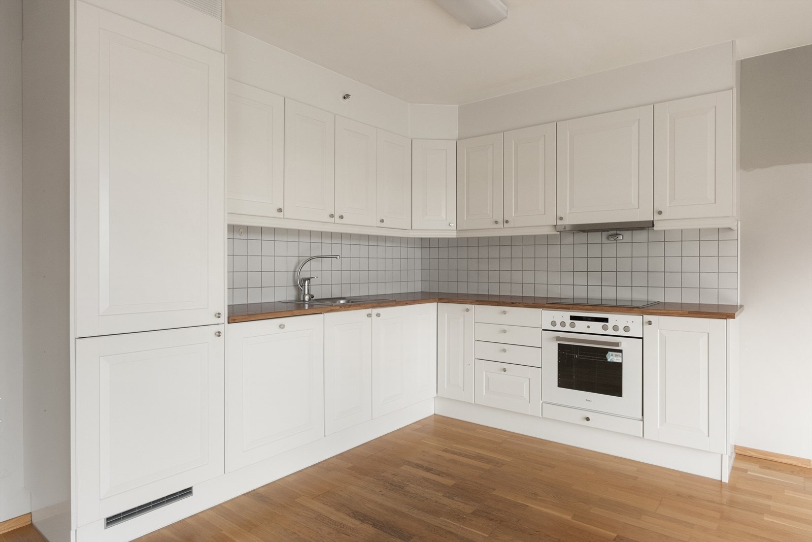 Kjøkkenet er i tidløs, hvit design og det er lukket mellom tak og toppen på innredningen som gir enklere rengjøring. Galleribilde