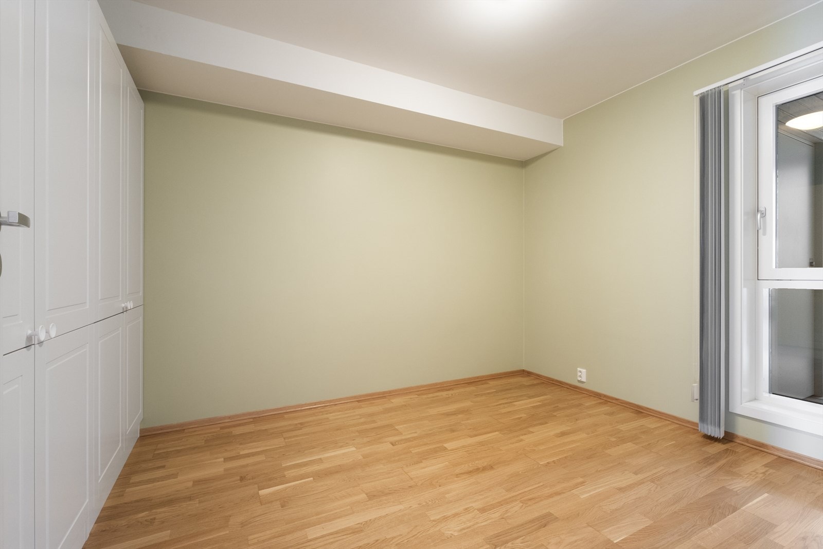 Soverom 2, med parkettgulv og malte plater på veggene, og også her er det montert et praktisk garderobeskap. Galleribilde