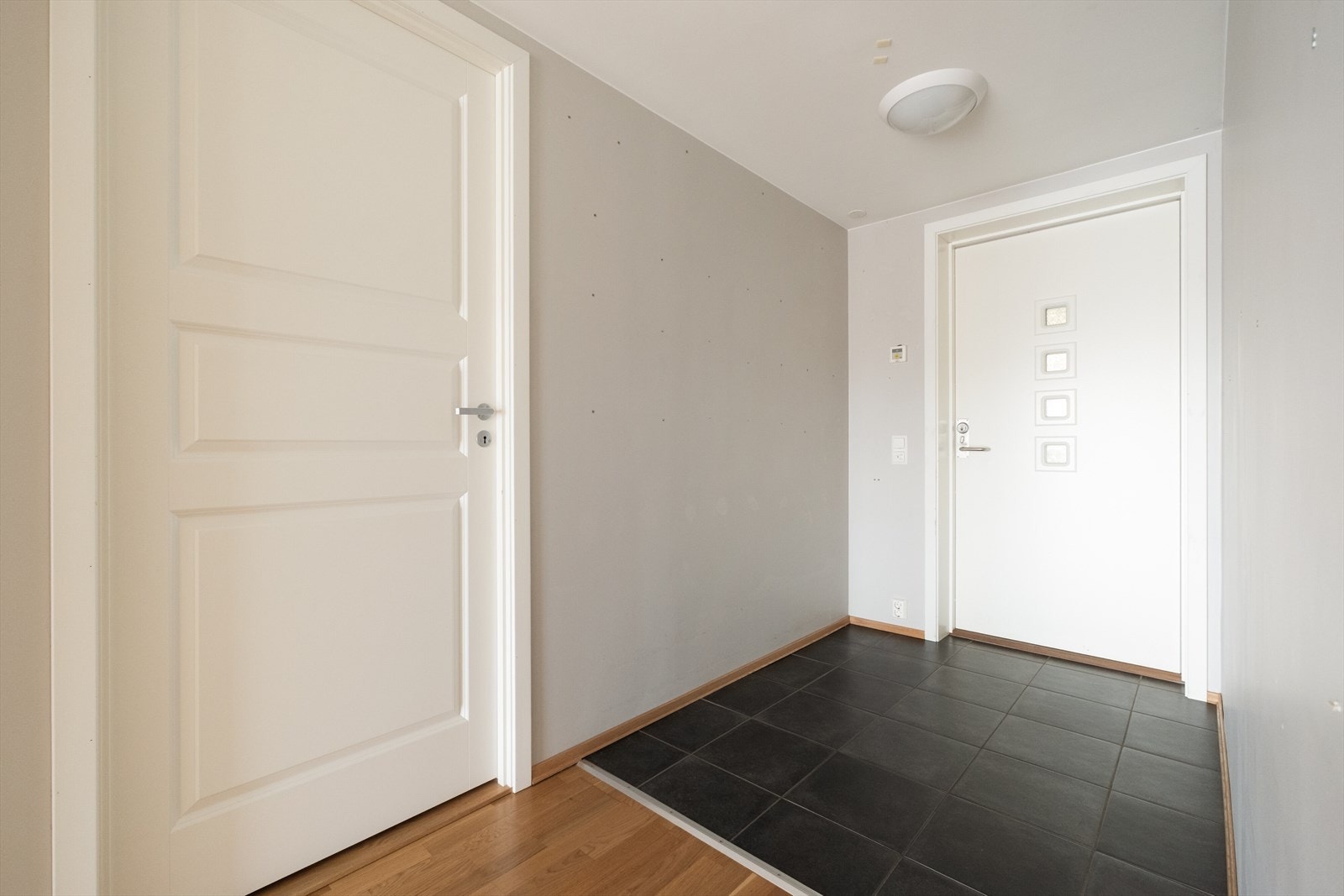 Entréen har flislagt gulv ved inngangsdøren og parkett videre inn i leiligheten. Galleribilde