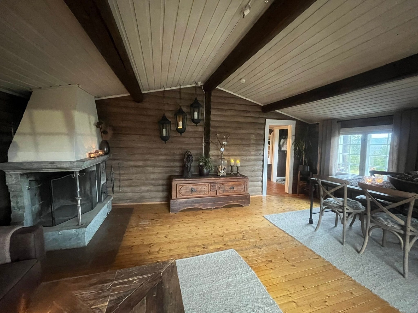 Hovedhuset har åpen himling og god takhøyde.
God og effektiv peis i kleberstein, med egen lukket vedovn. I stuen er det også montert en varmepumpe som gir behagelig og jevn oppvarming i den kalde årstiden. Galleribilde