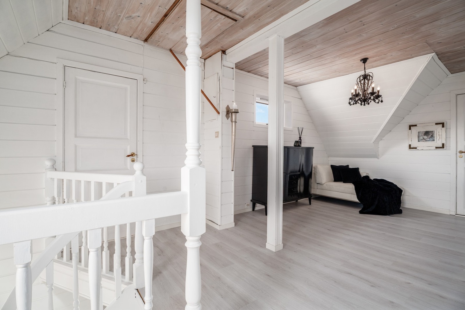 Oppe i 2. etasje har man loftstue med malt panel på veggflater. Legg merke til de flotte søylene og rekkverket ved trappa. Galleribilde