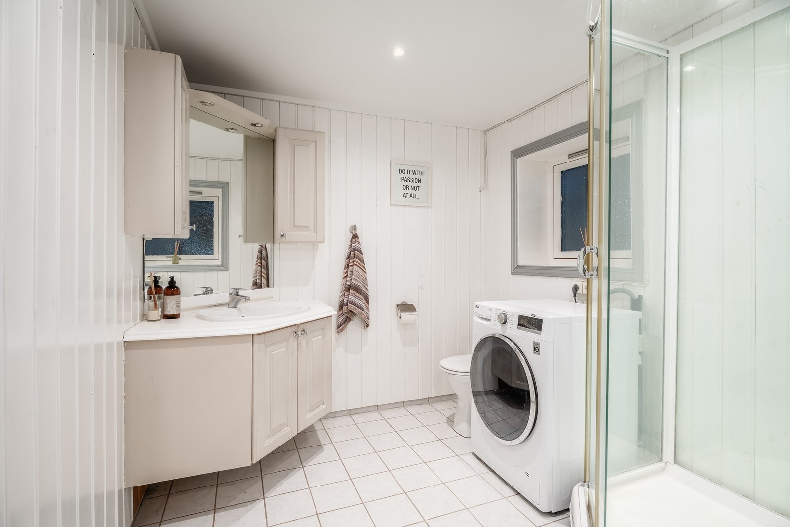 Badet i underetasjen har varmekabler i flislagt gulv, dusjkabinett, servantinnredning, toalett og opplegg for vaskemaskin. Galleribilde