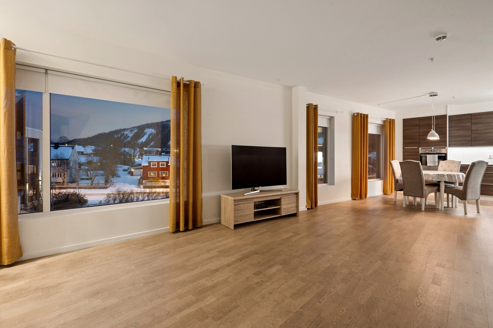 Leiligheten har store vindusflater som slipper inn godt med naturlig lys Galleribilde