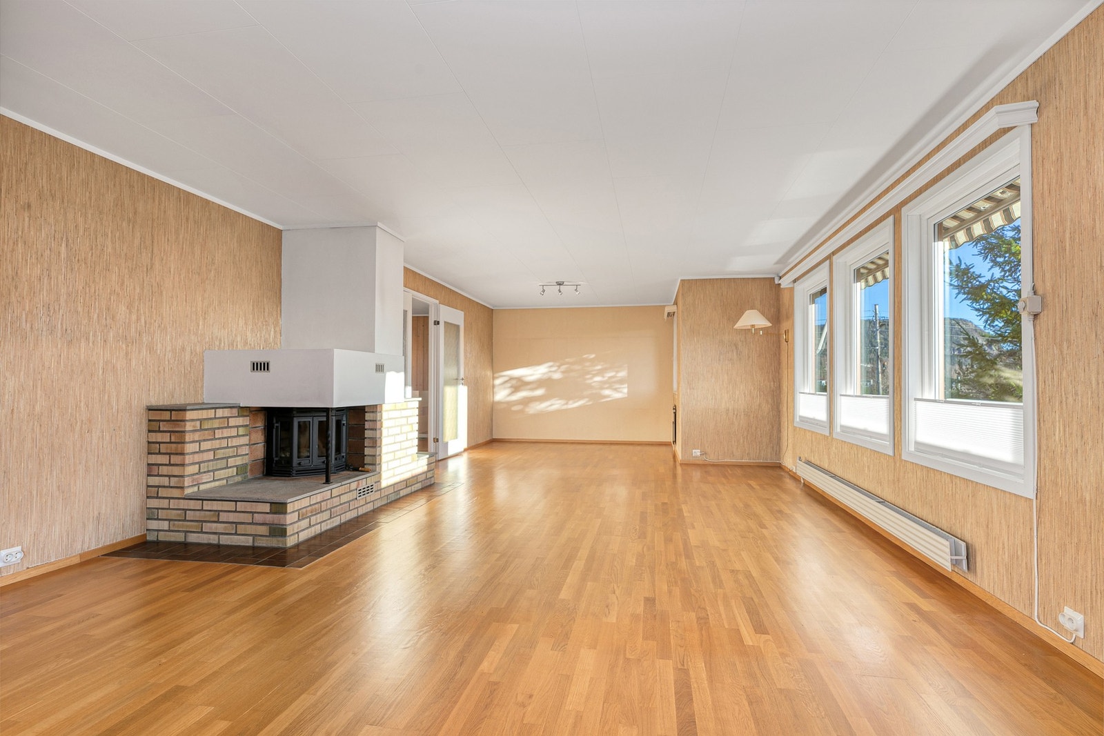 Stor lys stue med peis i 1. etasje. Galleribilde