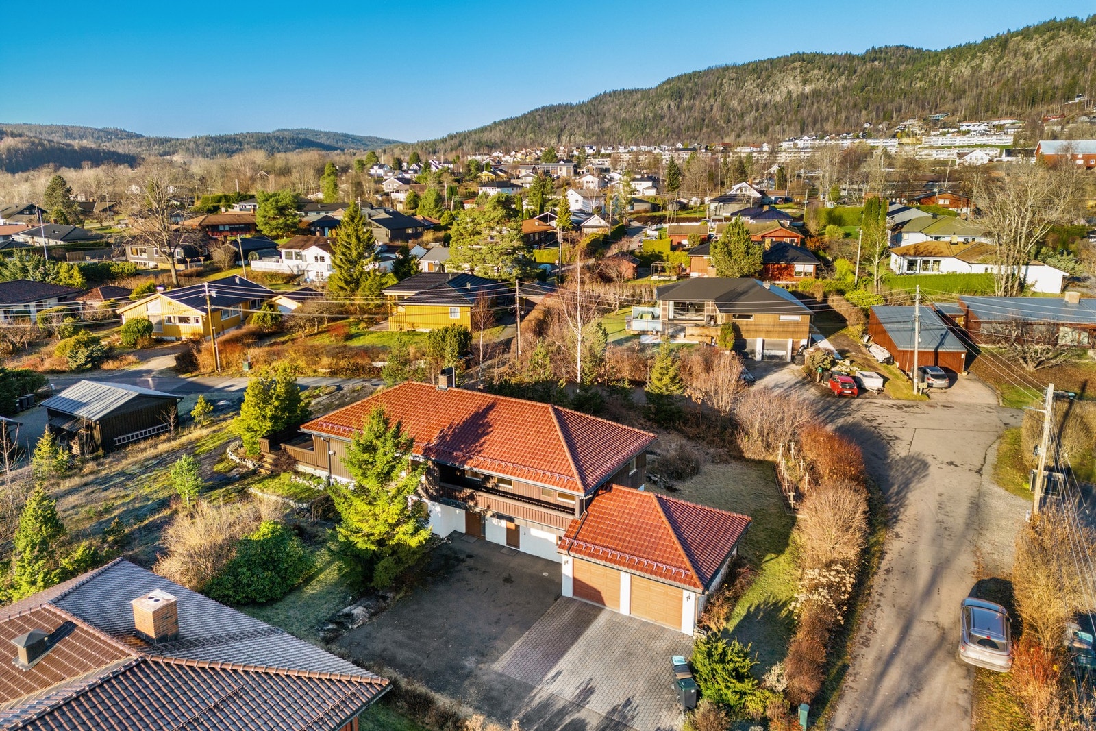 Eiendommen har en romslig gårdsplass med brostein og asfalt.Det er god plass til flere biler, samt enkel adkomst til dobbelgarasje. Galleribilde