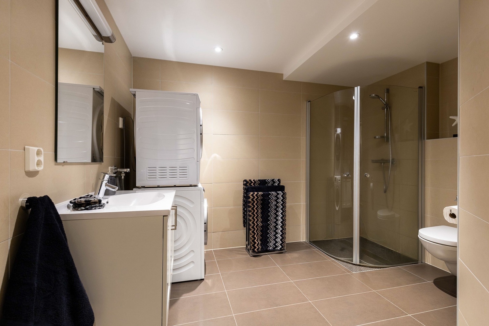 Badet er romslig og har et moderne uttrykk med flislagte overflater. Galleribilde