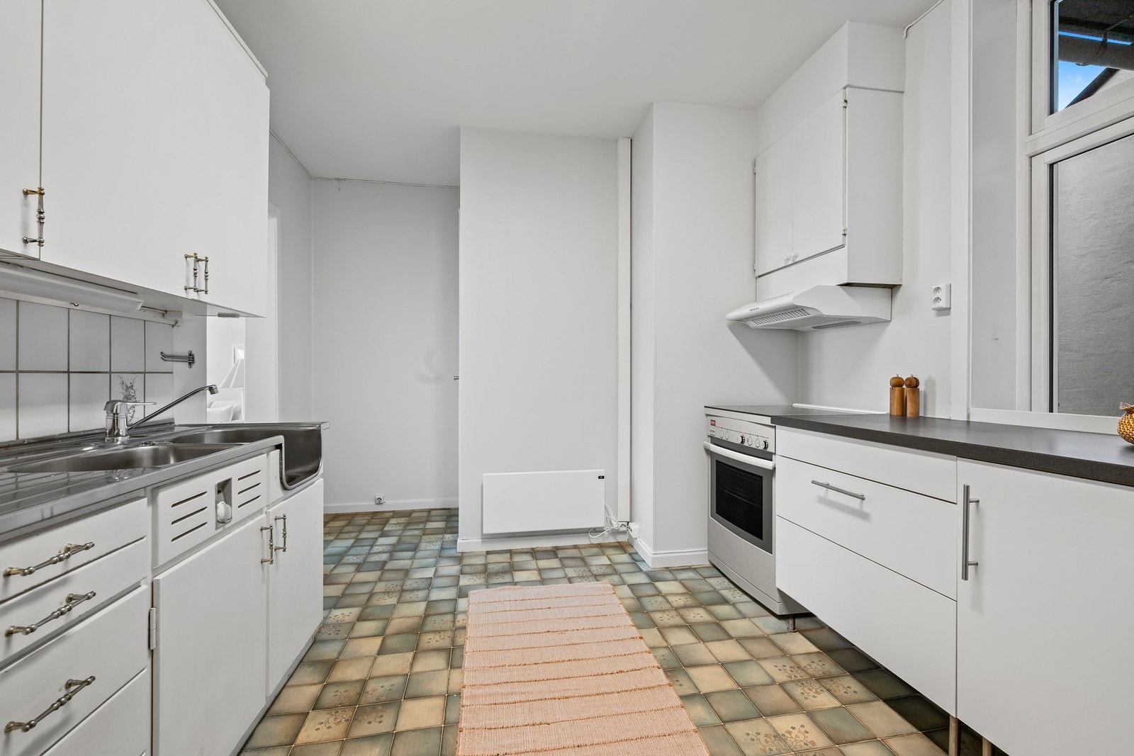 Innredningen har noe alder, men rommet fungerer godt i dag og har plass til frittstående hvitevarer. Galleribilde