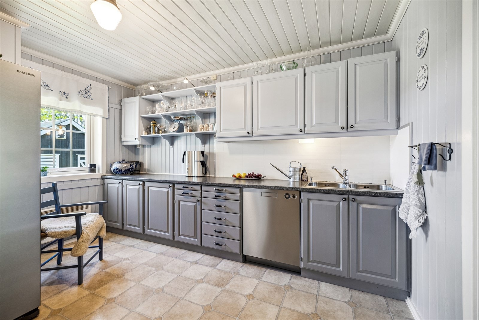 Innredningen har profilerte fronter, åpne hyller, laminatbenkeplate, nedfelt oppvaskkum og benkebelysning. Galleribilde