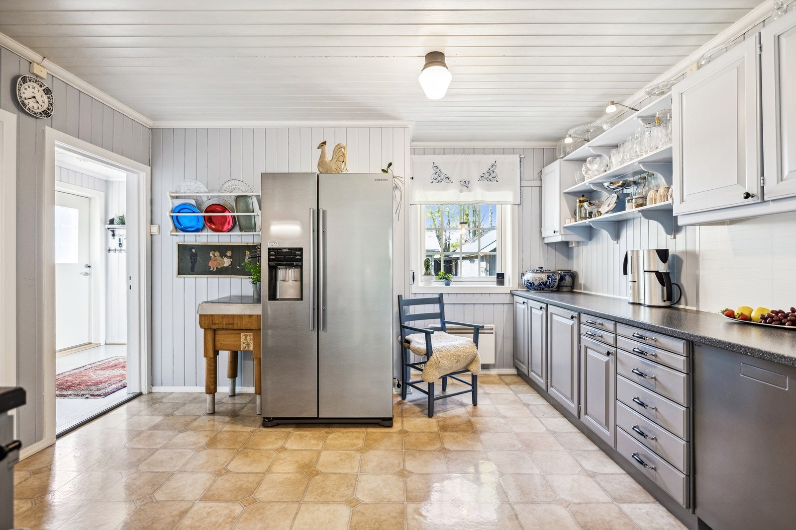 Laminatplater i flisetterligning gjør det enkelt å holde rent og bidrar til kjøkkenets trivelige stil. Galleribilde