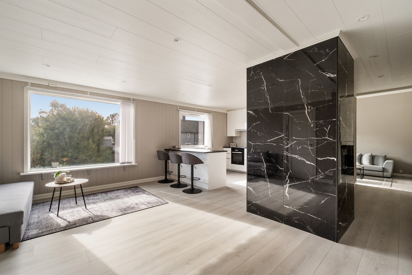 En vegg kledd i store keramiske fliser skaper en fin kontrast i rommet. Galleribilde