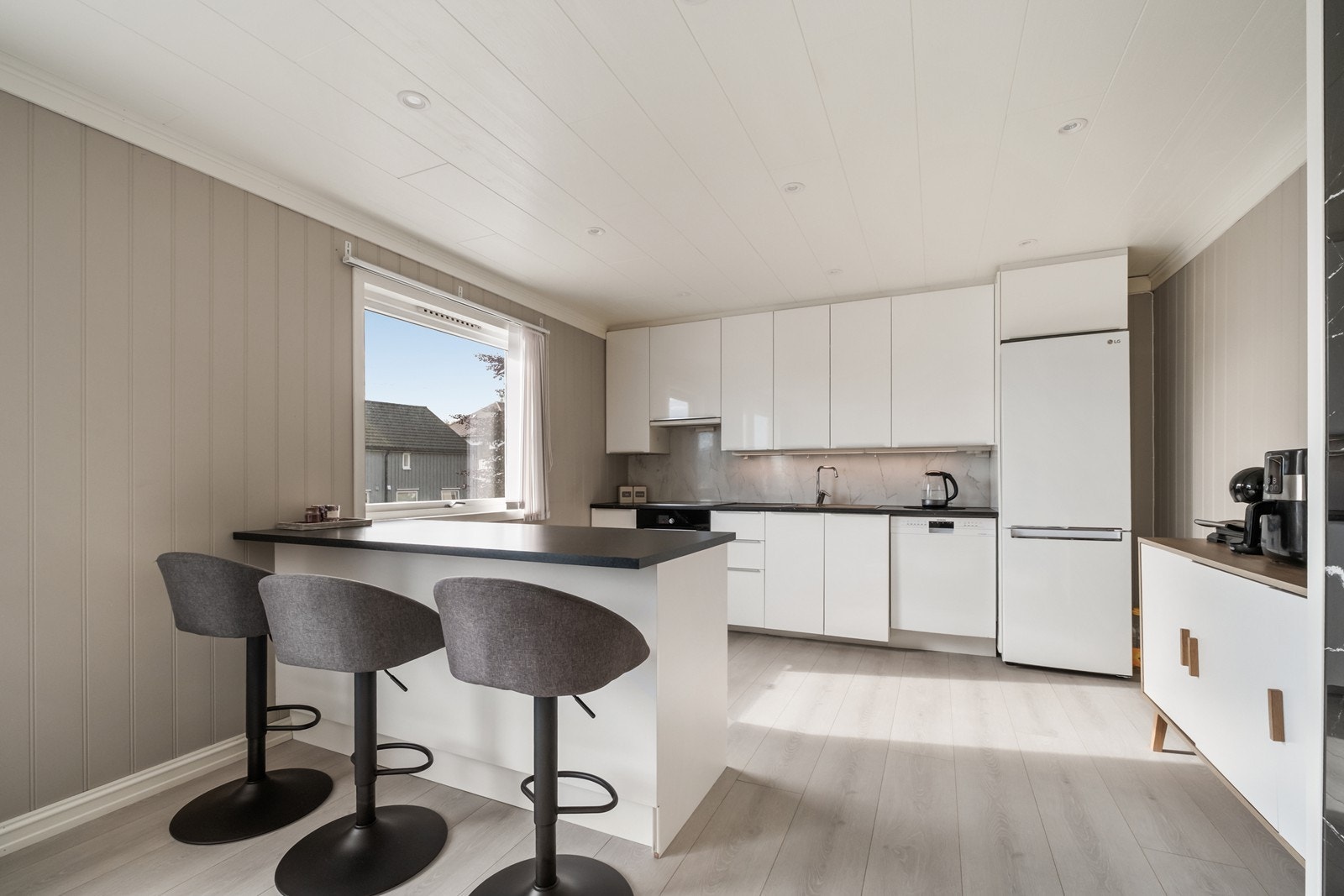 Kjøkkeninnredningen er tidløs i lyse toner med mørk benkeplate. Galleribilde