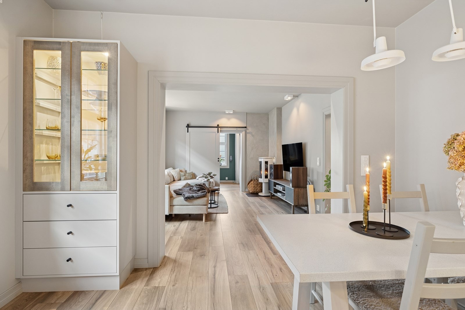 Den åpne forbindelsen mellom stuen og spiseplassen gir en harmonisk og praktisk overgang, som skaper et sosialt og funksjonelt oppholdsrom. Galleribilde