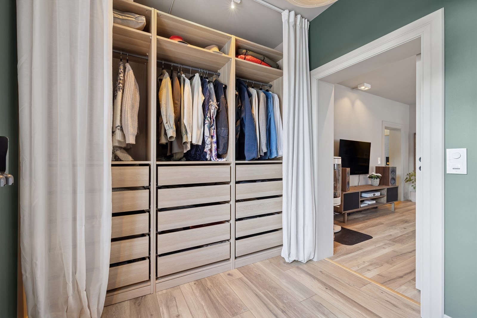 I dette rommet finner du en praktisk garderobeløsning med både skuffer og oppheng, som gir god plass til klær, sko og tilbehør. Her kan du enkelt holde orden, samtidig som garderoben gir et stilrent og funksjonelt preg til rommet. Galleribilde