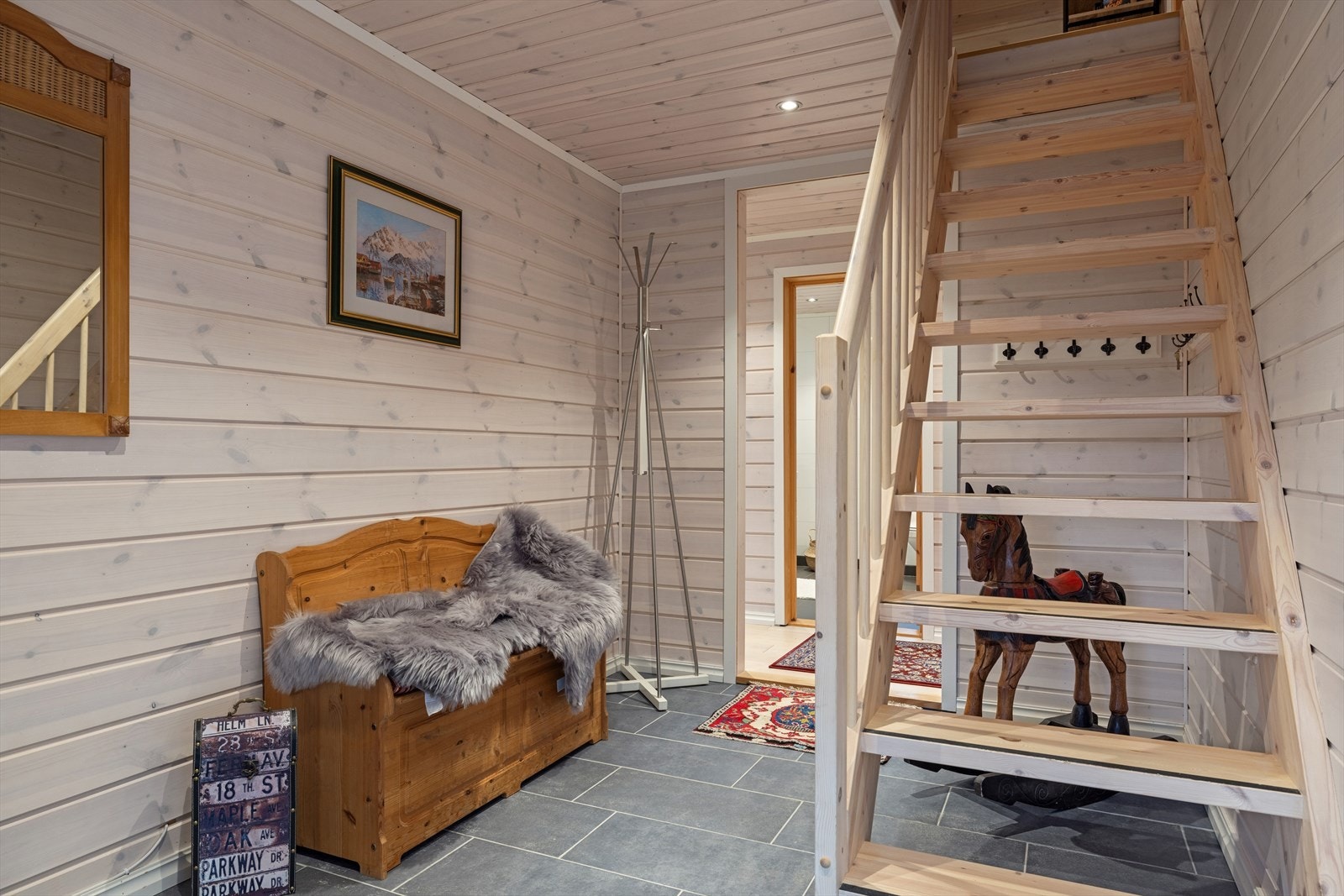 Innbydende gang med god plass til å kle av og på, samt sittebenk og praktisk oppbevaring. Trappen leder opp til loftestasje, som gir ekstra areal og fleksible bruksområder. Galleribilde