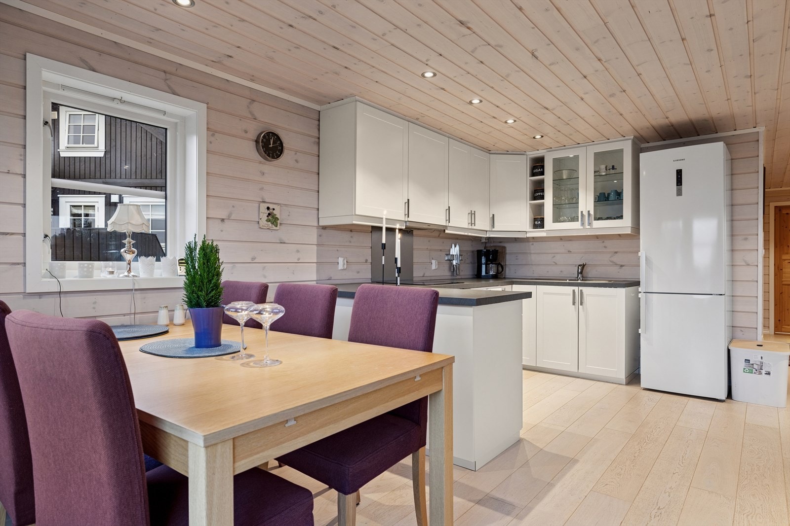 Praktisk kjøkken med god arbeidsplass og smarte oppbevaringsløsninger. Hvit innredning gir et ryddig uttrykk, og spiseplassen er plassert nært for enkel servering. Galleribilde