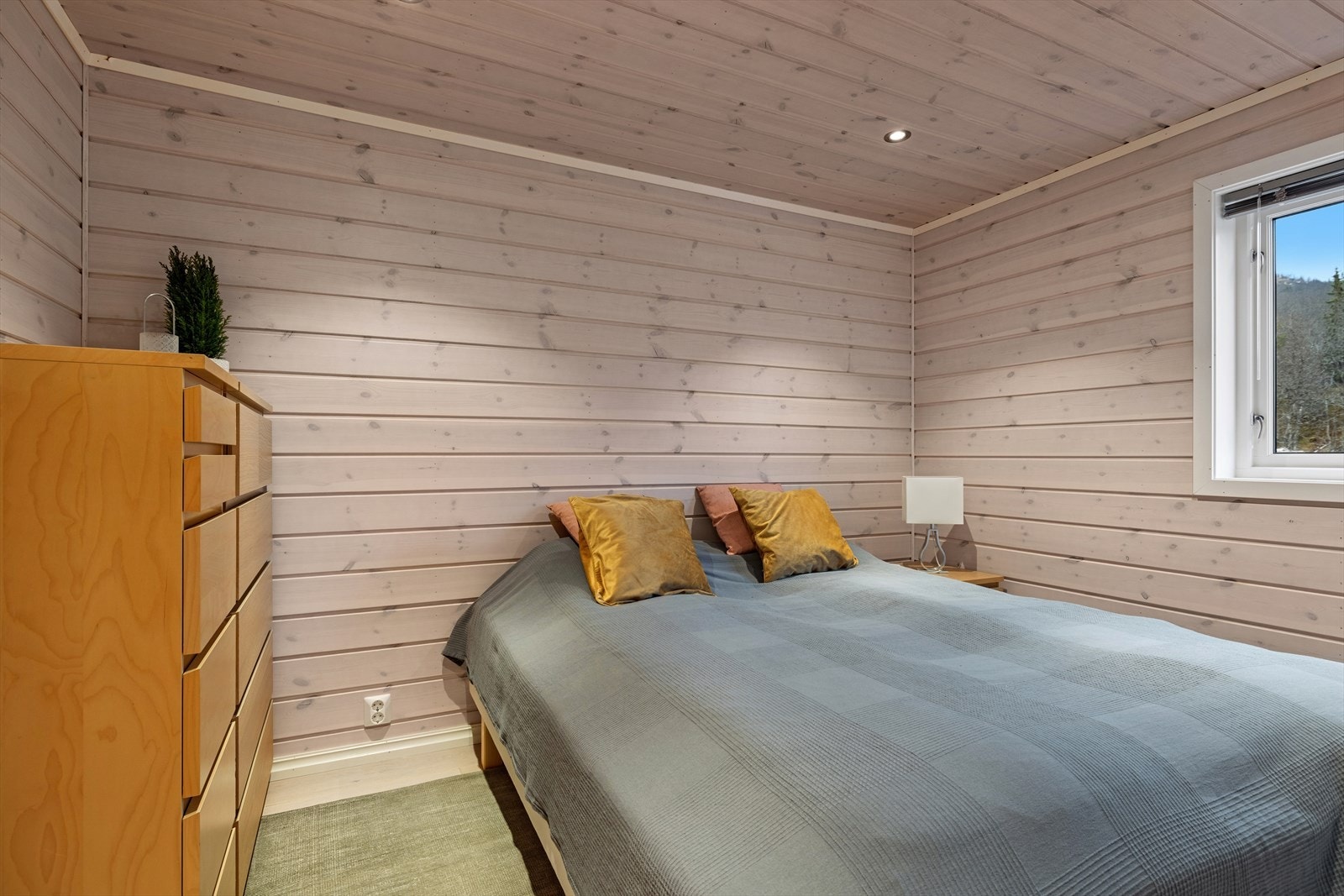 Soverommet har klassiske panelvegger og harmoniske farger som skaper en lun atmosfære. God plass til dobbeltseng og garderobeløsning, samt nattbord på begge sider - et rom med komfort. Galleribilde