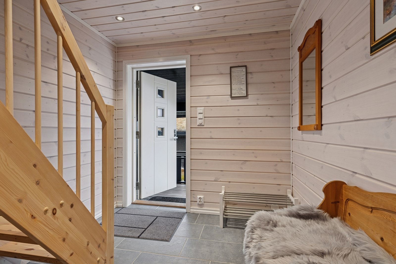 Velkommen inn i en lys og trivelig gang med panelvegger og flislagt gulv med varmekabler. Galleribilde