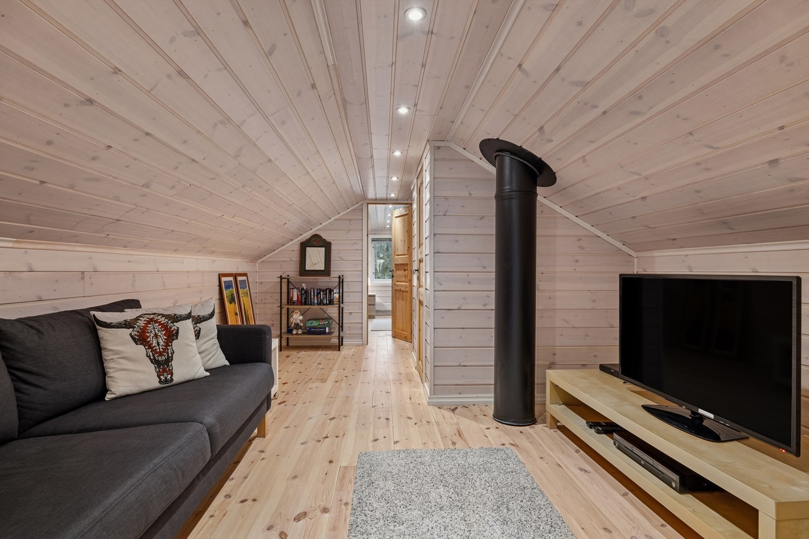 Koselig loftstue med god plass til sofakrok og TV. Perfekt som ekstra oppholdsrom eller lekeområde, med lune materialer og praktisk planløsning. Galleribilde