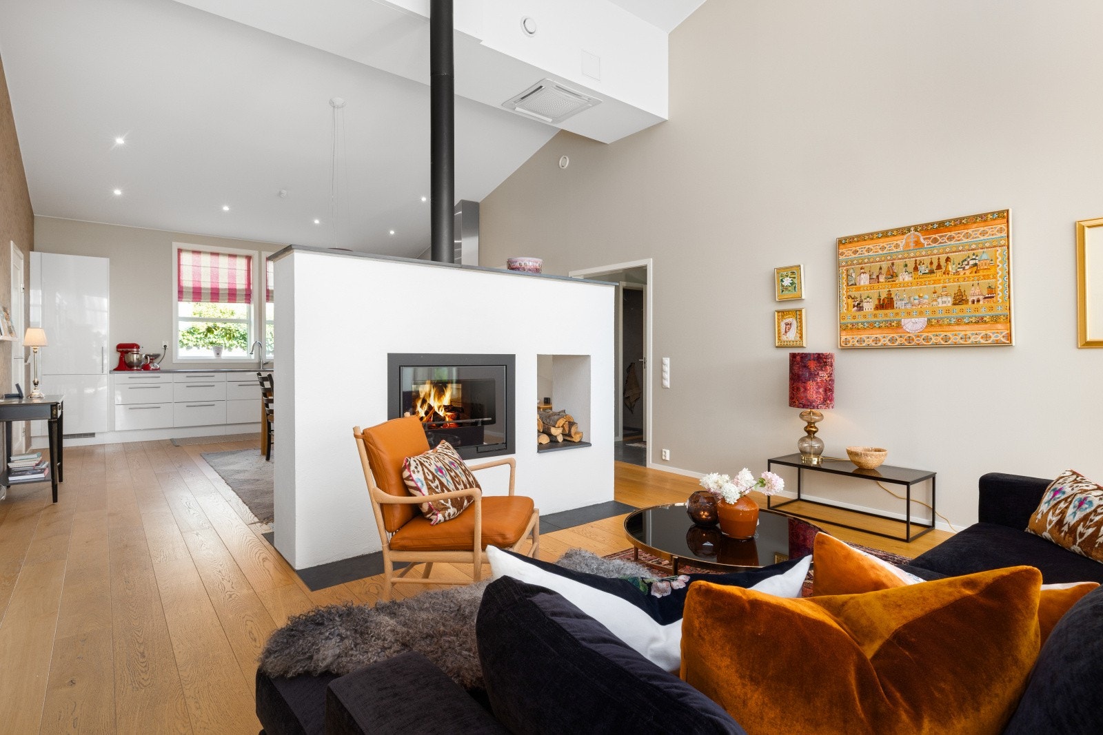 Som et flott midtpunkt i rommet er det en murt peis med peisinnsats, som gir et naturlig skille mellom stue og spisestue/kjøkken. Galleribilde