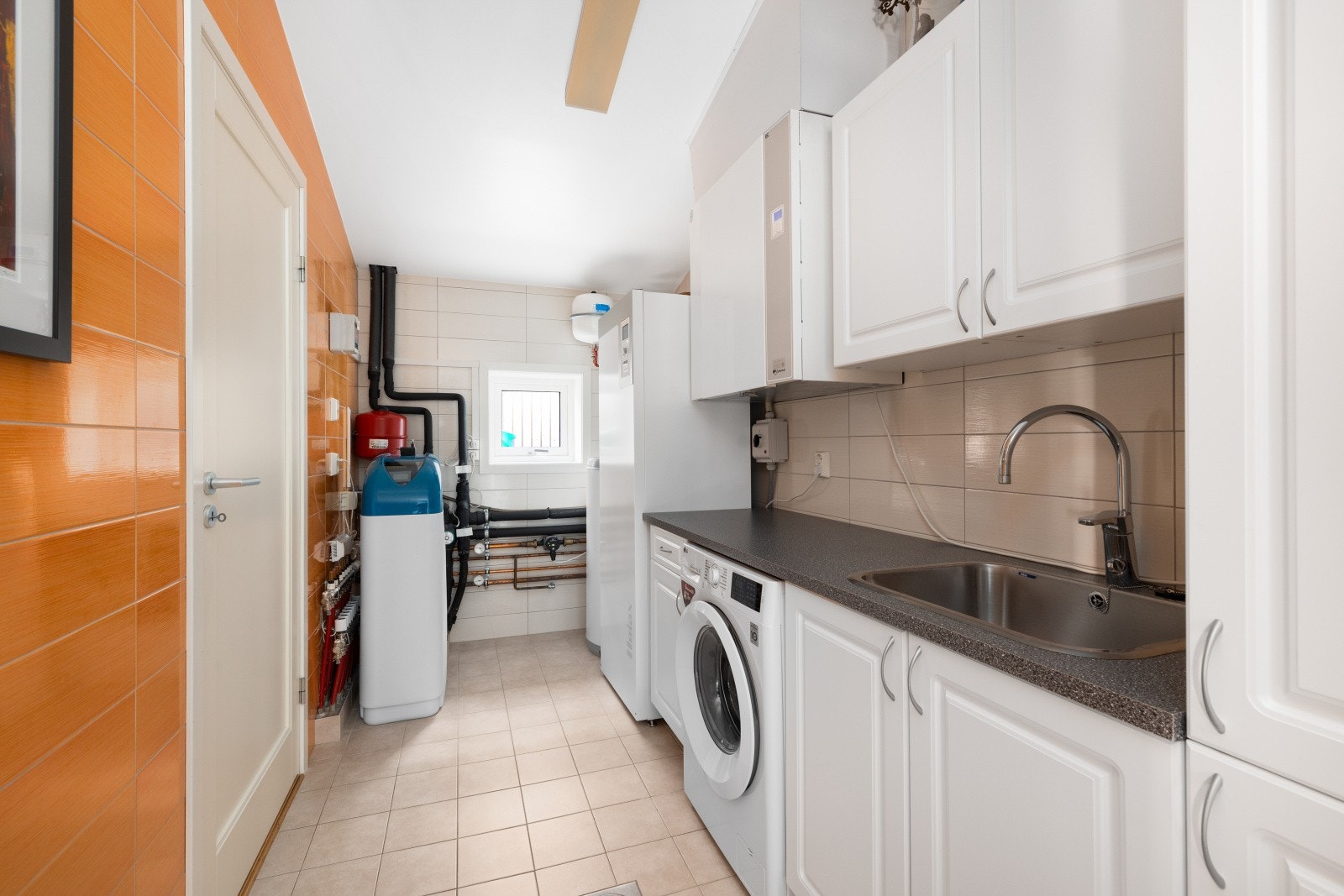 Boligen har også et vaskerom som er praktisk plassert like ved inngangsdøren. Rommet har fliser på gulv og vegger, vannbåren gulvvarme og balansert ventilasjon. Galleribilde