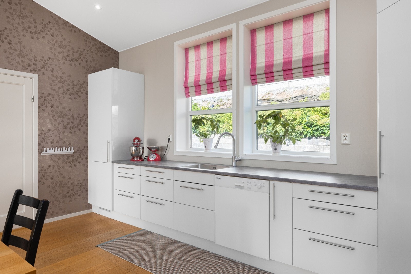 Lys og moderne kjøkkeninnredning fra 2011 med god skap- og benkeplass. Innredningen har hvite glatte fronter og laminert benkplate med nedfelt oppvaskkum. Galleribilde