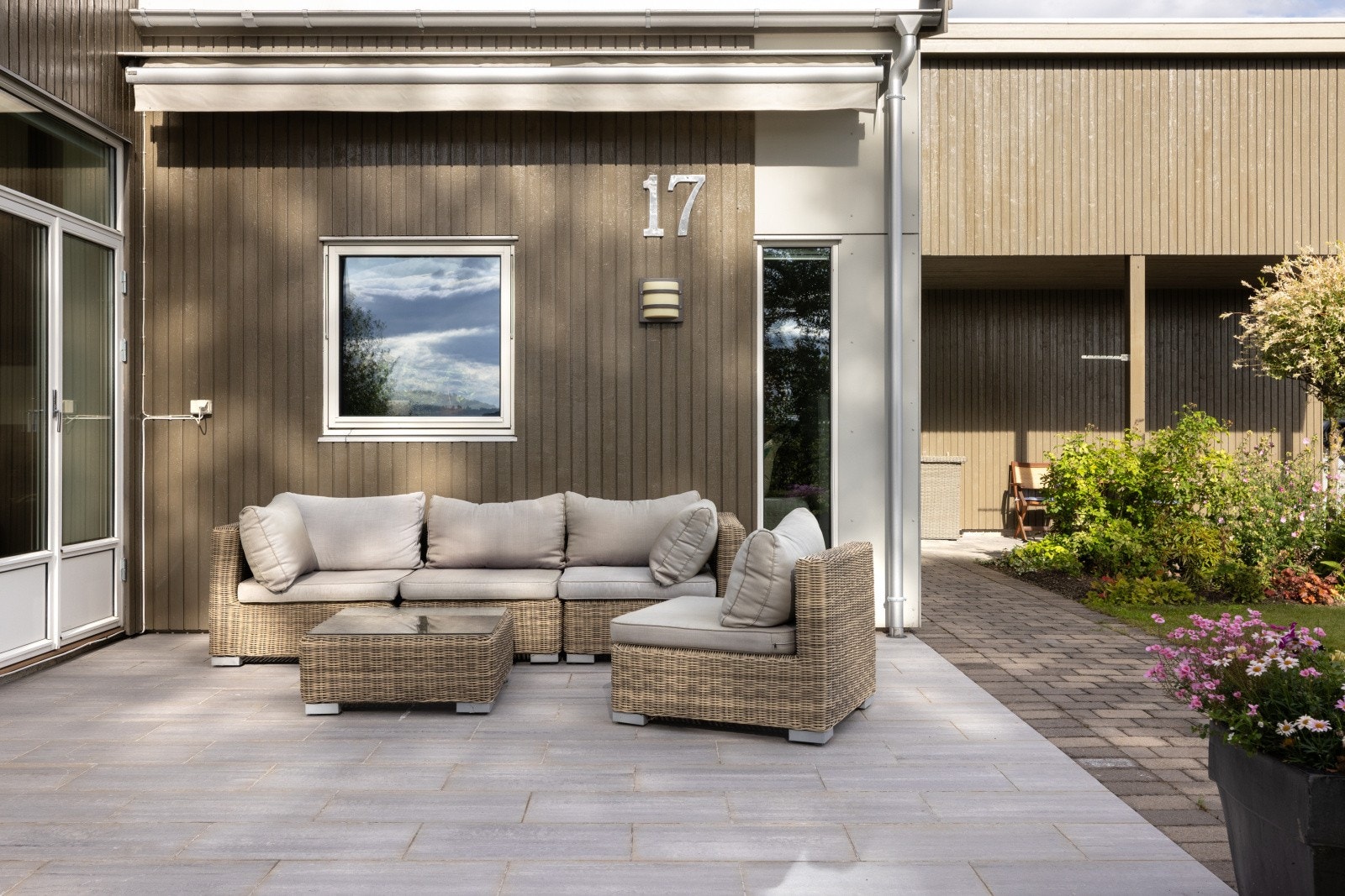 Terrassen har flislagt gulv og god plass til sittegruppe. Det er også montert markise, utebelysning og utvendig stikkontakt. Tomten er ryddig, lettstelt og pent opparbeidet. Galleribilde