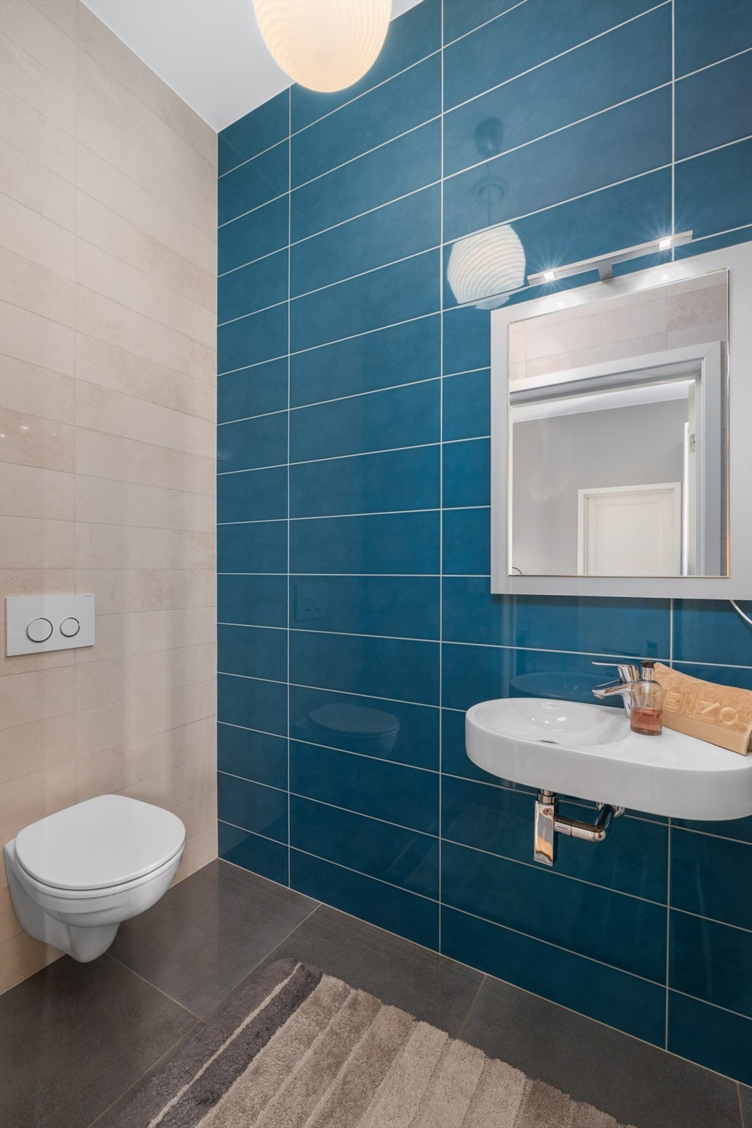 Toalettrommet har fliser på gulv og vegger, vannbåren gulvvarme og god takhøyde. Rommet er utstyrt med vegghengt servant, speil med belysning over og vegghengt toalett. Galleribilde