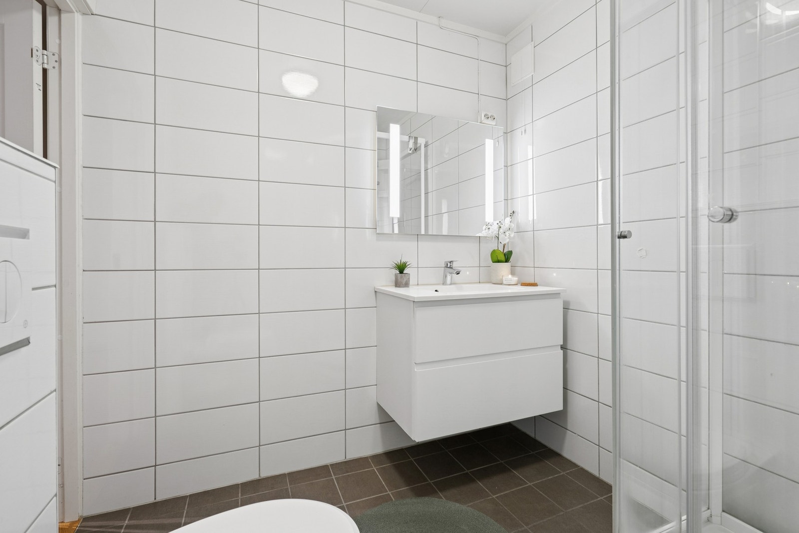 Badet har flislagt gulv med elektriske varmekabler og fliser på vegger. Det ble pusset opp i 2017. Galleribilde