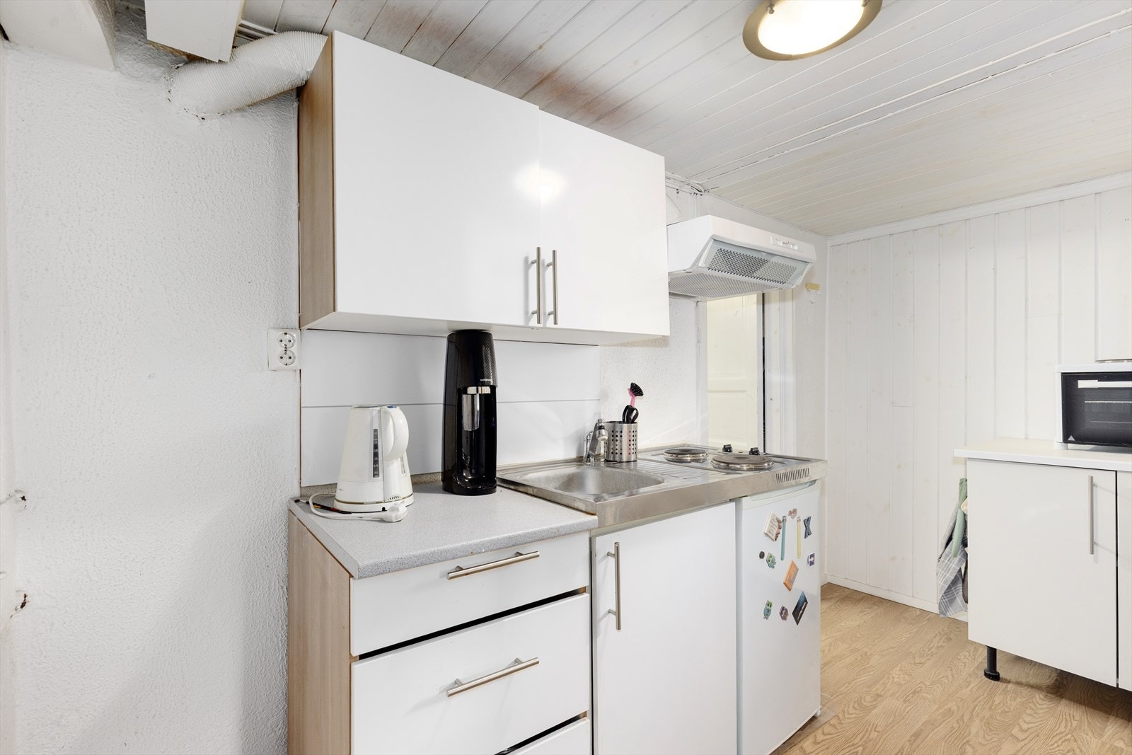 I kjeller er det et enkelt kjøkken med slette fronter og laminat benkeplate. Det er integrert koketopp og ventilator. Galleribilde