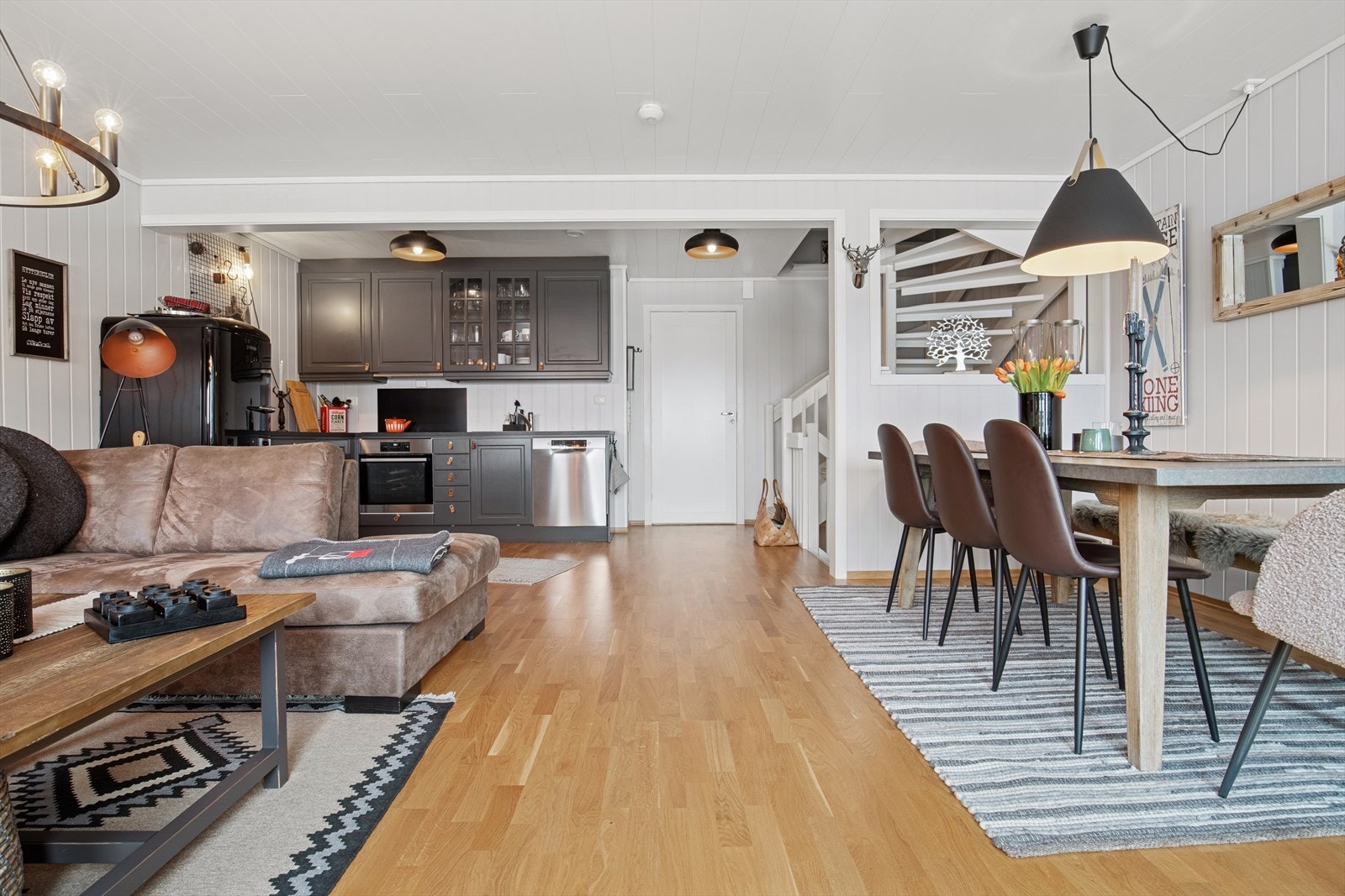 Den åpne løsningen i trappen til stuen og kjøkkenløsning gjør rommet lyst og sosialt. Galleribilde