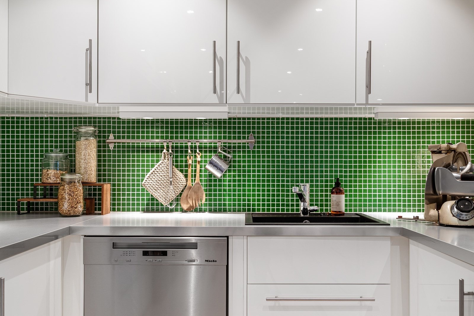 De grønne flisene gir en tøff kontrast mot resten av kjøkkenet Galleribilde