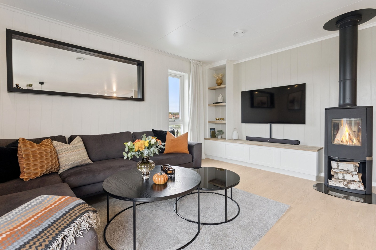 Rentbrennende peisovn er et fint midtpunkt som gir god varme. Stuen har integrert TV-benk med hyller og skap som gir et moderne utrykk. Galleribilde