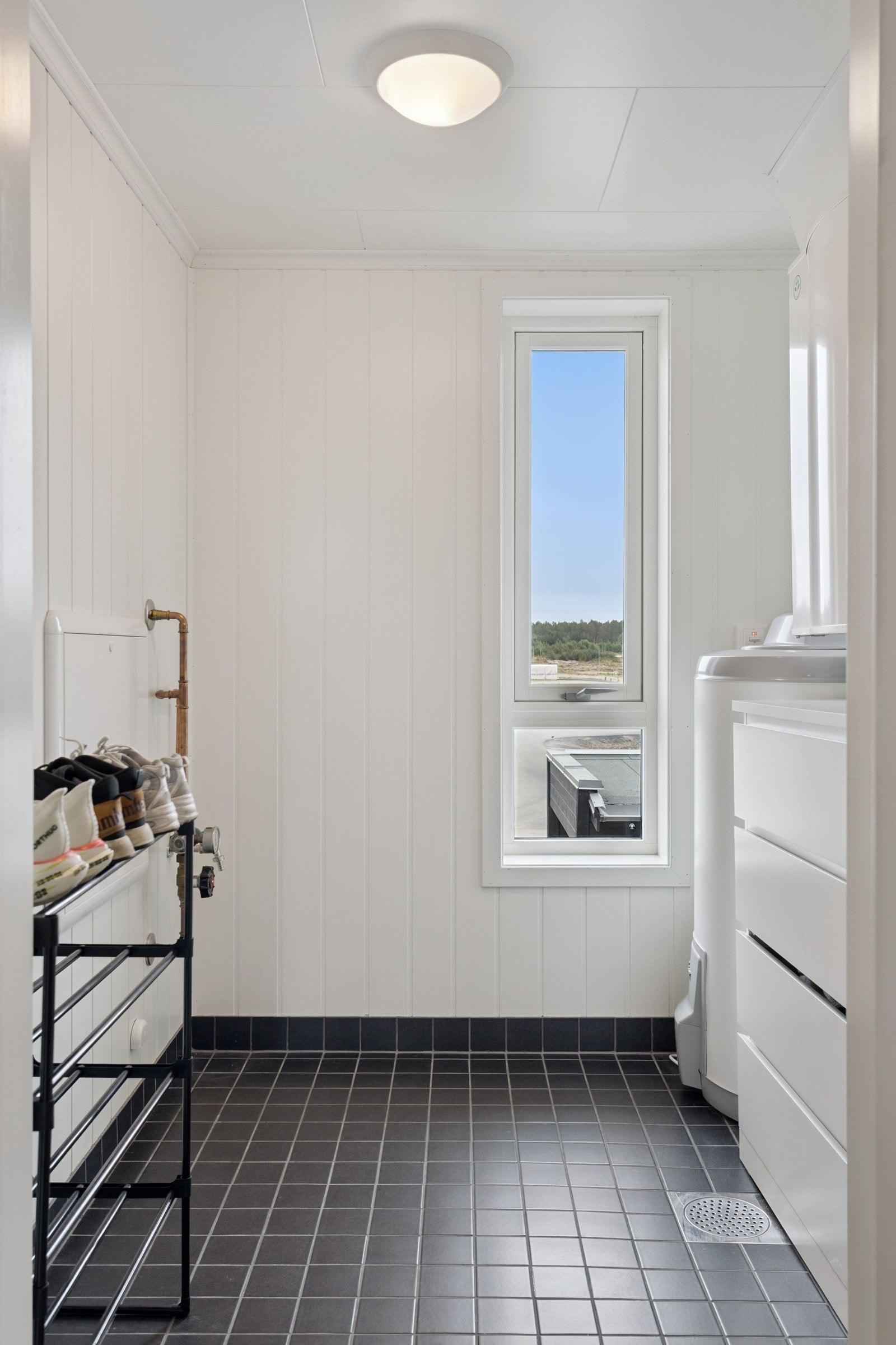 Innvendig bod. God plass til oppbevaring med flislagt gulv med sluk. Galleribilde