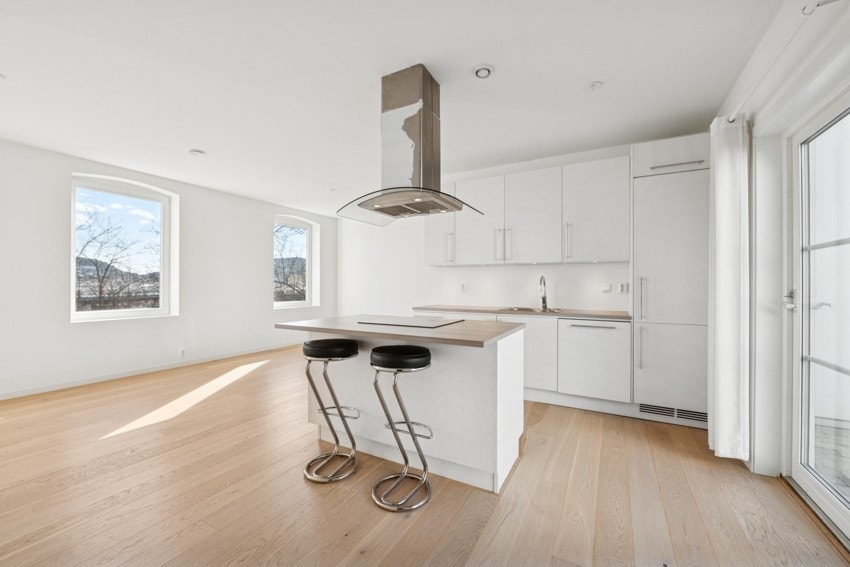 Lys og funksjonell kjøkkenløsning med plass til spisebord. Galleribilde