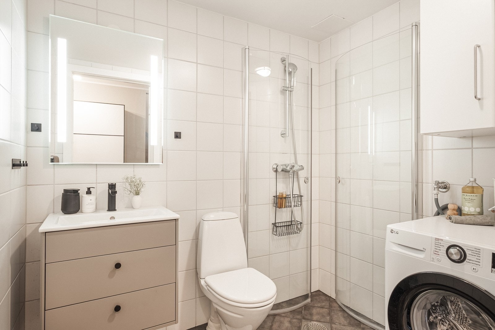 Helfliset bad fra 2005 med gulvmontert toalett, benkeskap med servant, dusjdører i glass og opplegg for vaskemaskin. Det er gulvvarme på bad. Galleribilde