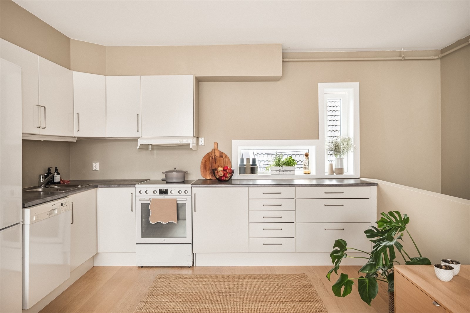 Kjøkkeninnredning med slette fronter. Det er laminat benkeplate med nedfelt vask og opplegg til hvitevarer. Hvitevarer på kjøkkenet medfølger handelen. Galleribilde