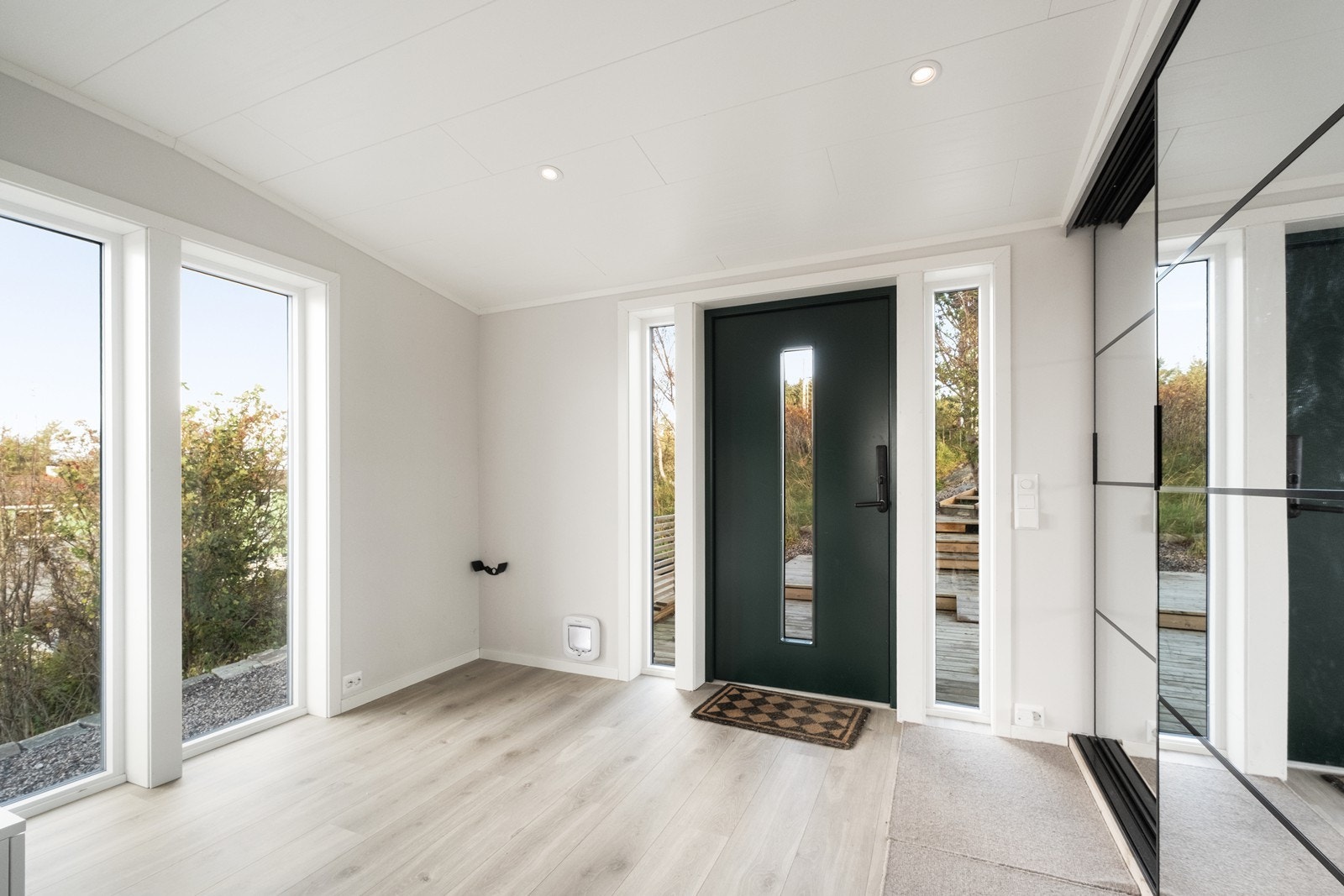 Stor og romslig entrè/ hall med store vindusflater og skyvedørsgarderobe med speilfronter. Galleribilde