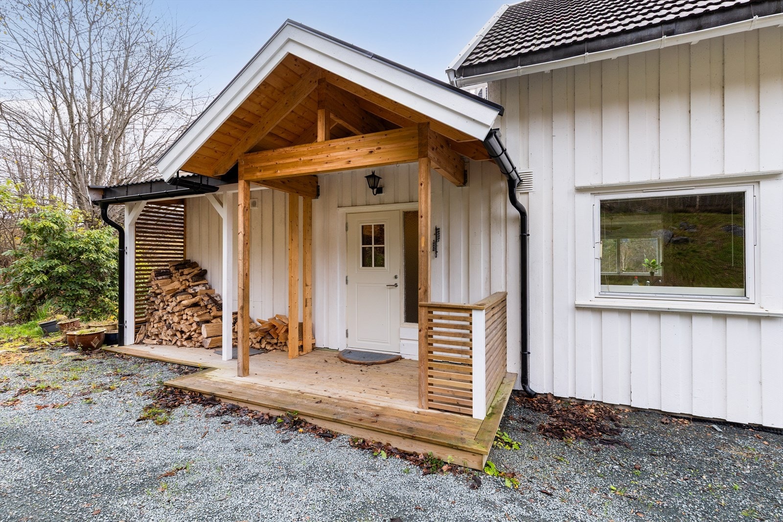 Boligen har et overbygget inngangsparti med platting fra 2024. Ved inngangspartiet er det også tillaget et praktisk vedskjul. Galleribilde