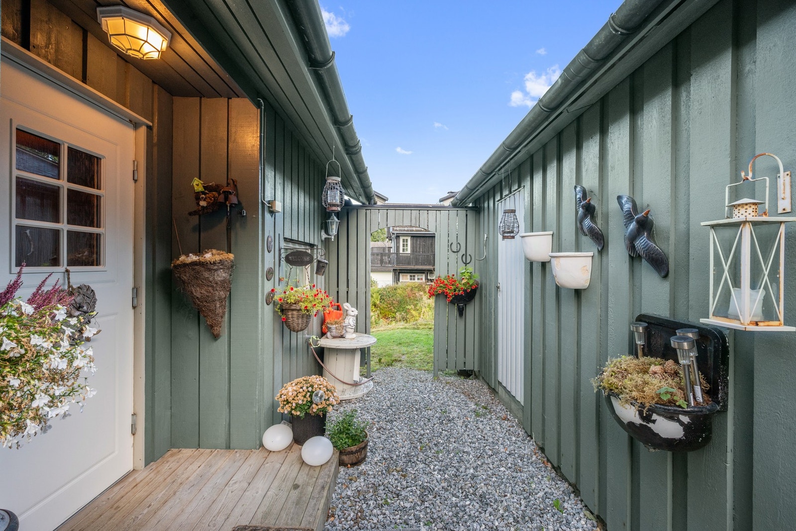 Eneboligen har et pent, inntrukket inngangsparti med gruslagt adkomst, repos i tre og takmontert utebelysning. Galleribilde