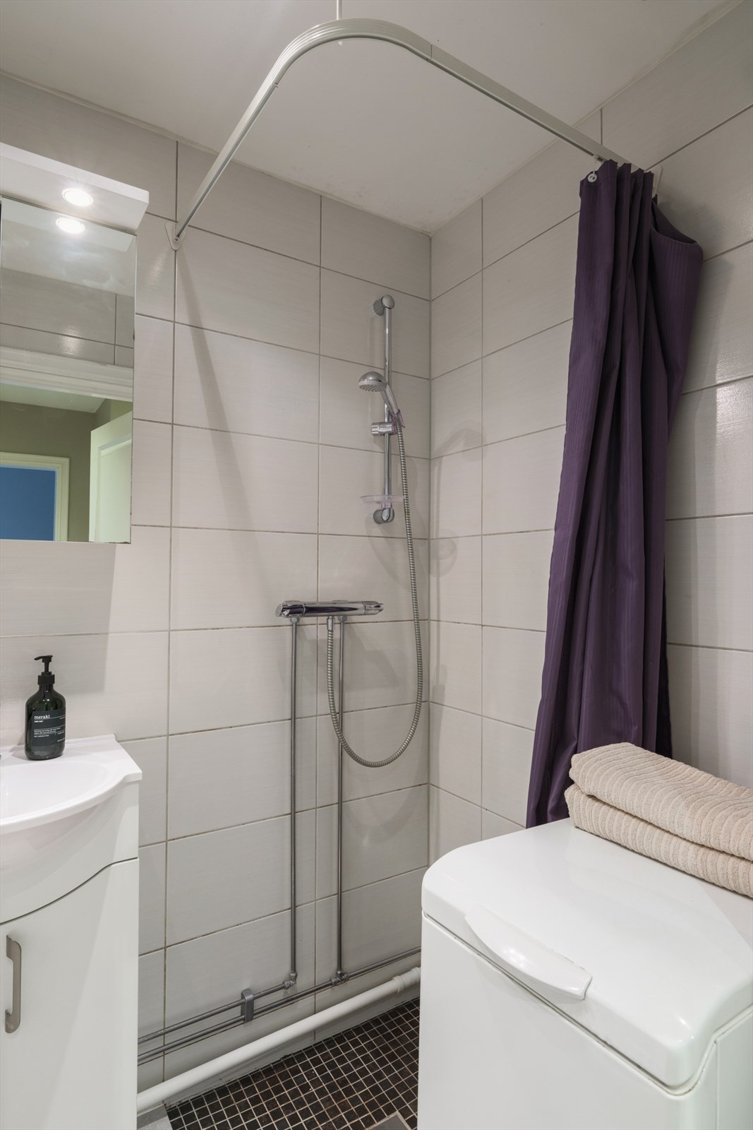 Gulvet er flislagt med varmekabler, veggene er flislagt, og taket er malt med integrerte downlights som gir et lyst og delikat rom. Galleribilde