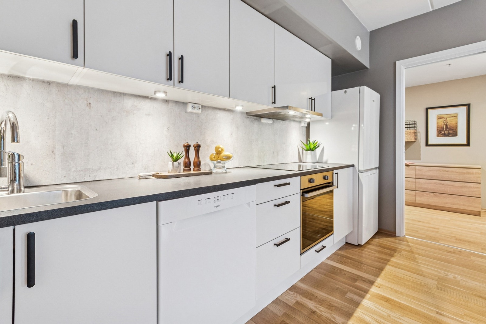 Tidløs kjøkkeninnredning med god skap- og benkeplass. Integrerte hvitevarer som induksjonstopp, stekeovn og oppvaskmaskin. Galleribilde