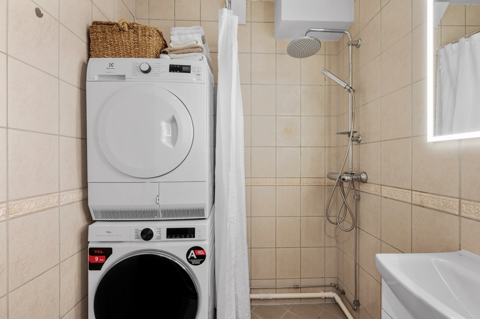 Flislagt bad med plass til vaskemaskin og tørketrommel. Galleribilde