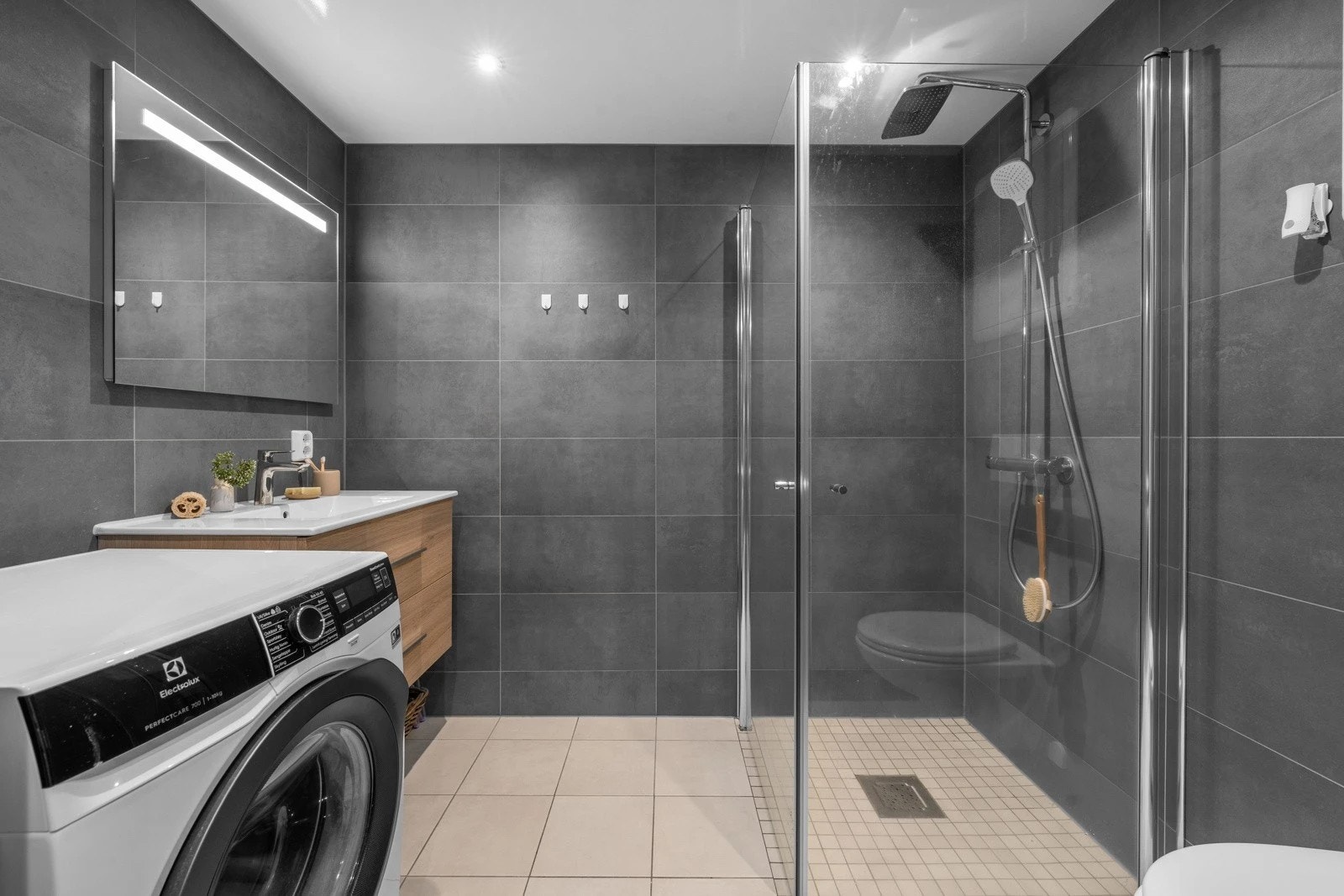 Bad med dusjhjørne og opplegg for vaskemaskin. Galleribilde
