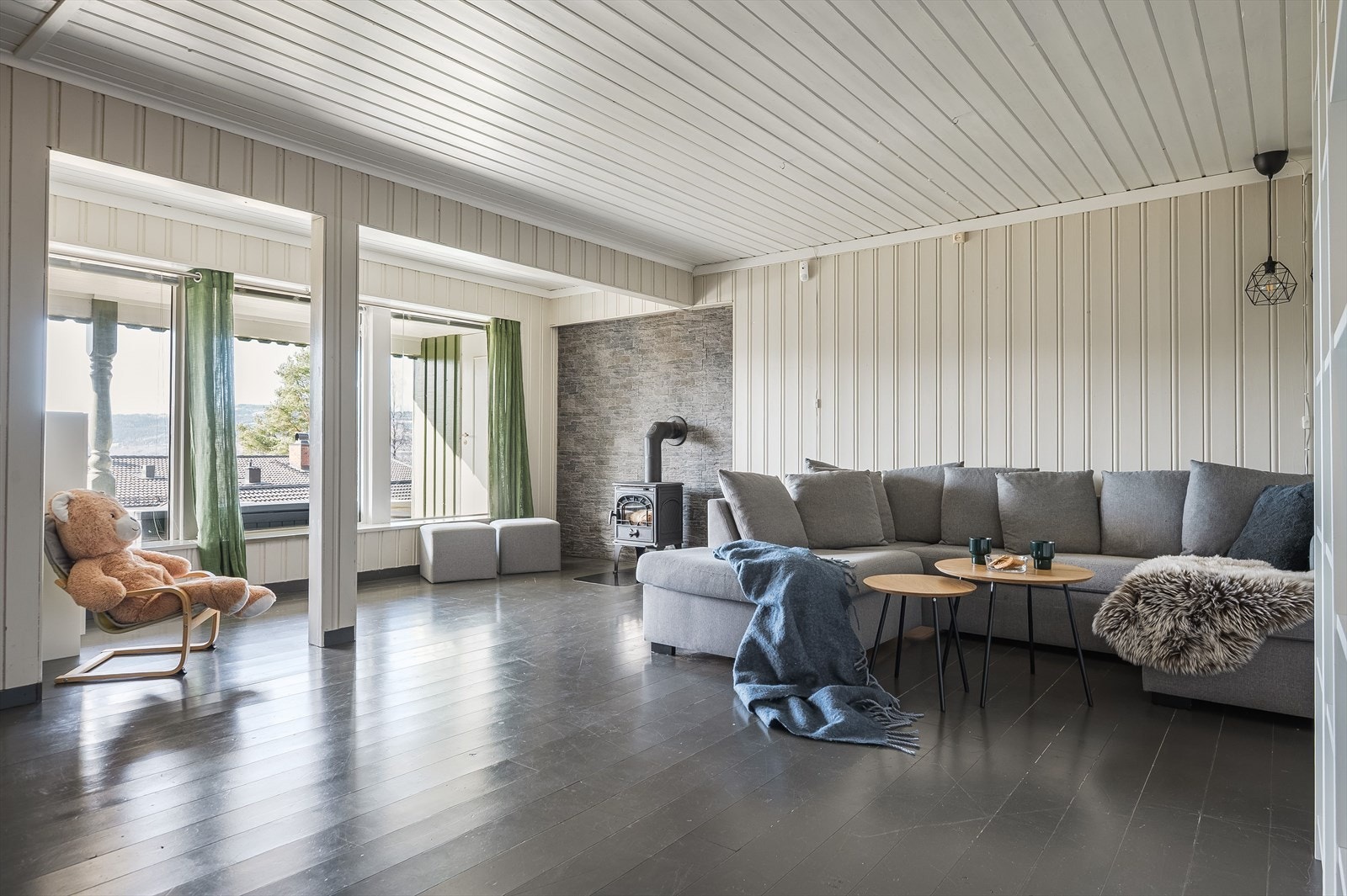 Kjellerstue med peis og store vindusoverflater Galleribilde